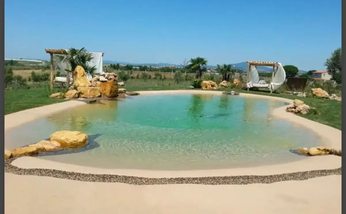 Fiberglass pool installation with stone patio surround in Sussex County