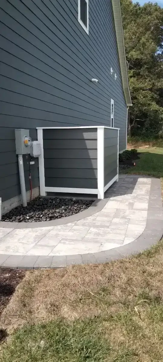 Curved paver walkway beside an outdoor utility screen