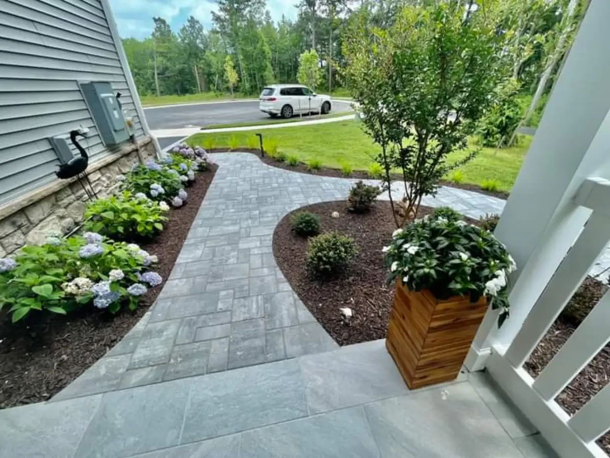 Curving front walkway through landscaped garden beds