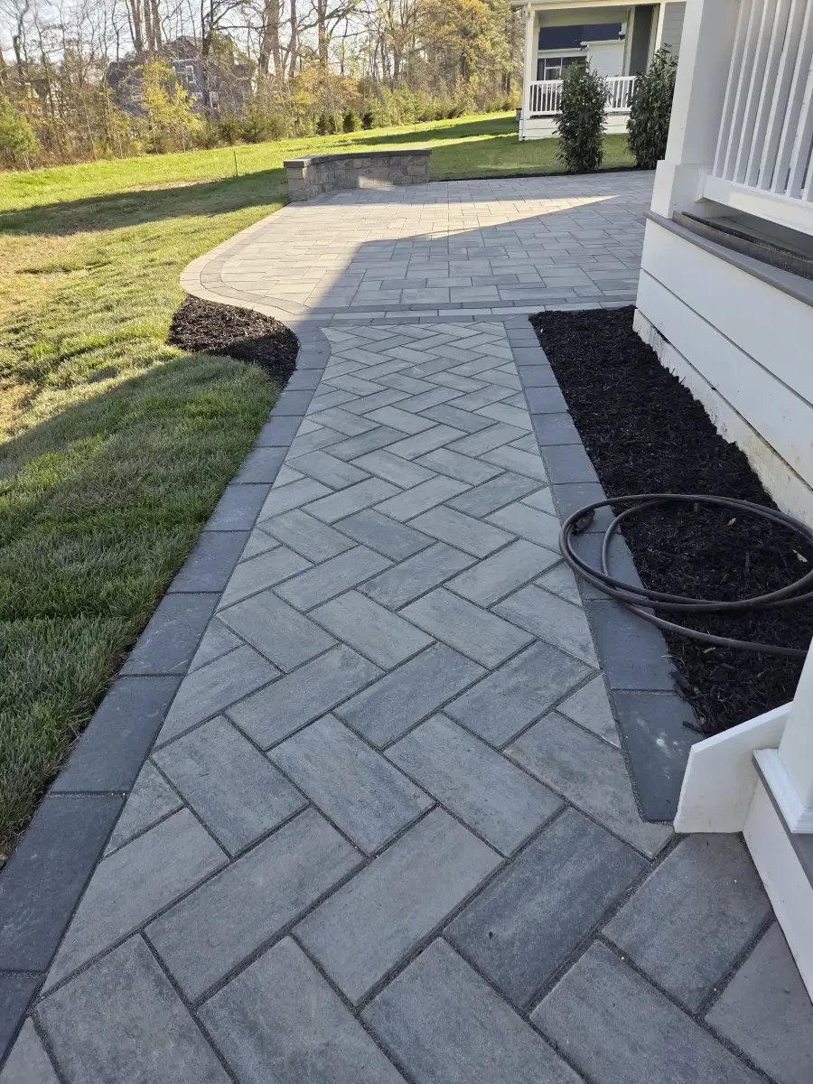 Curved paver patio along the back of a house