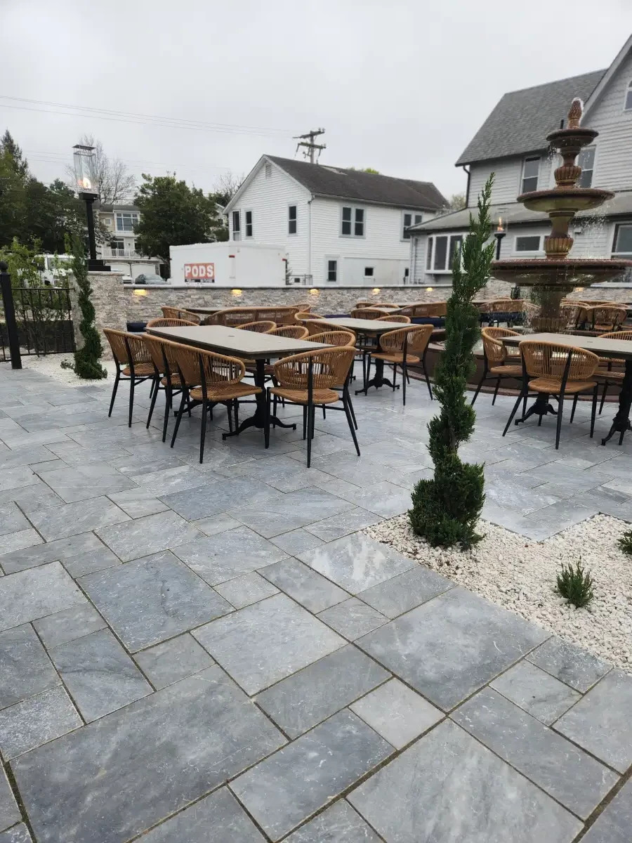 Paver patio with dining furniture beside a house