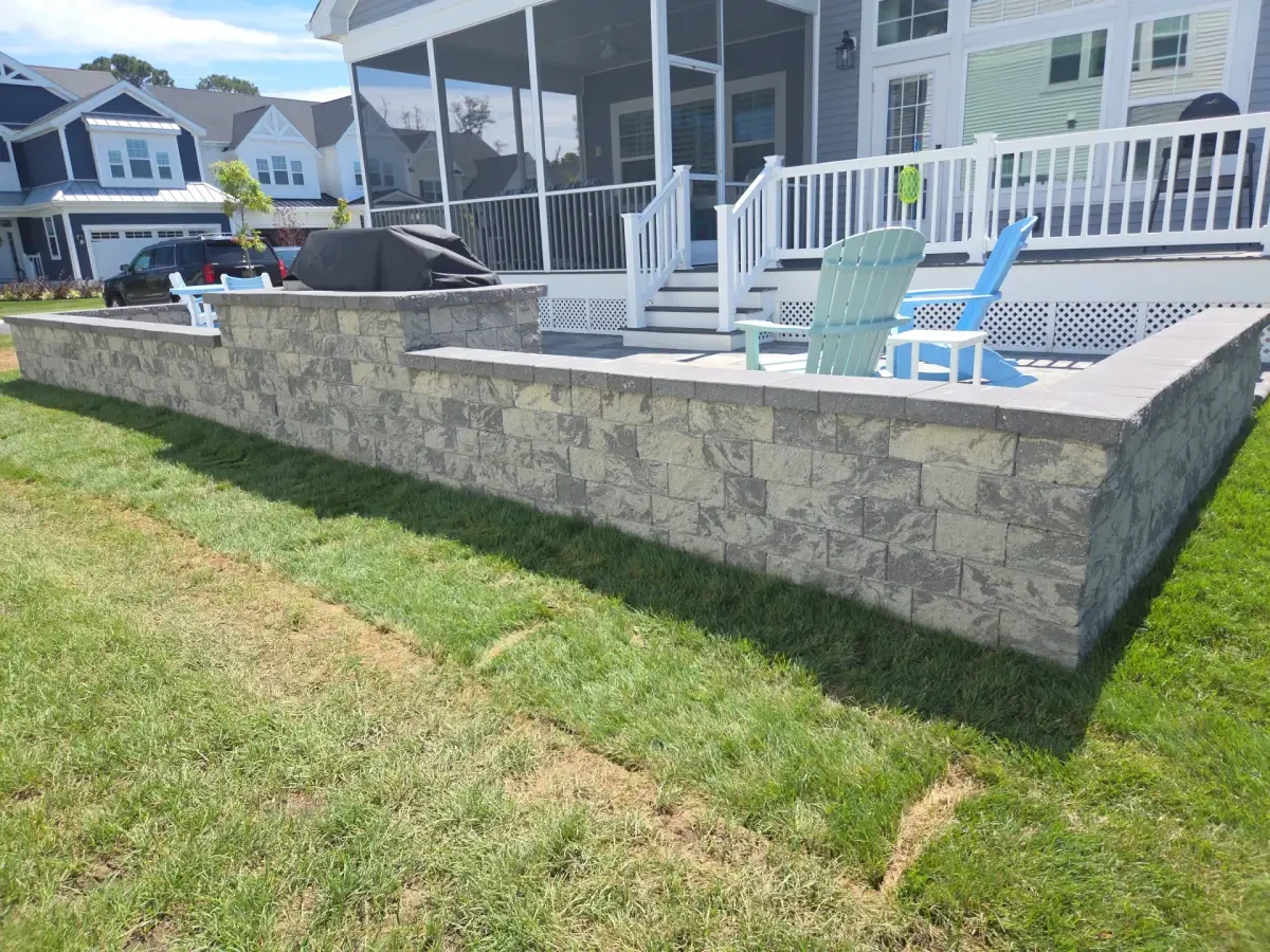 Raised paver patio supported by a stone retaining wall